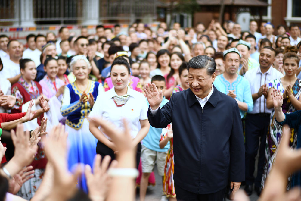 2022年7月13日，习近平在新疆维吾尔自治区乌鲁木齐市天山区固原巷社区考察时，向各族群众挥手致意。新华社记者 燕雁 摄